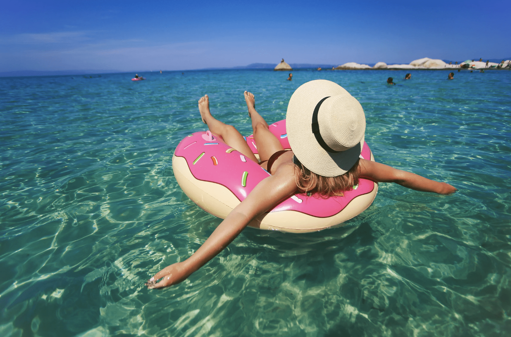 Girl relaxing on a floaty at the beach, embracing self-care and recovery during summer